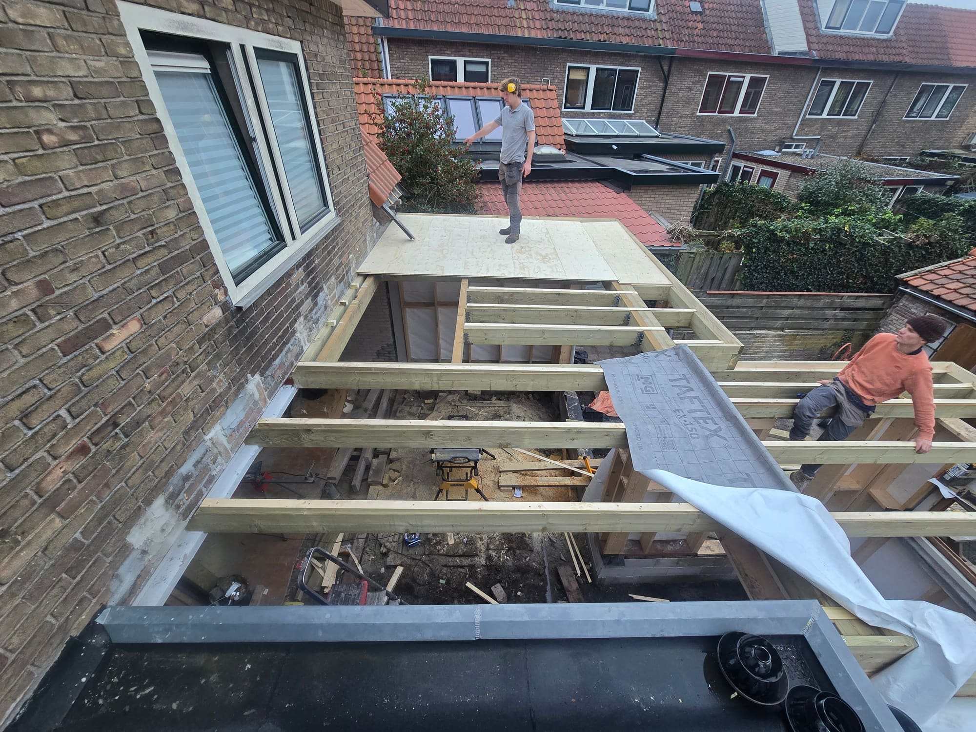 Dakopbouw in uitvoering met nieuwe houten balklaag, dakbeschot en zinken dakrand