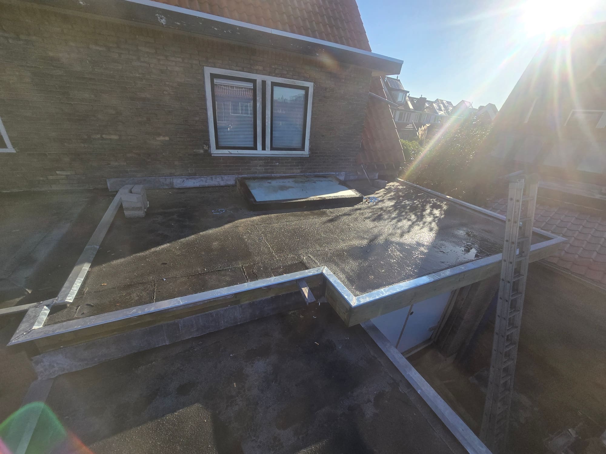 Plat dak met nieuwe zinken daktrim rondom, klaar voor de isolatie- en dakbedekkingslaag